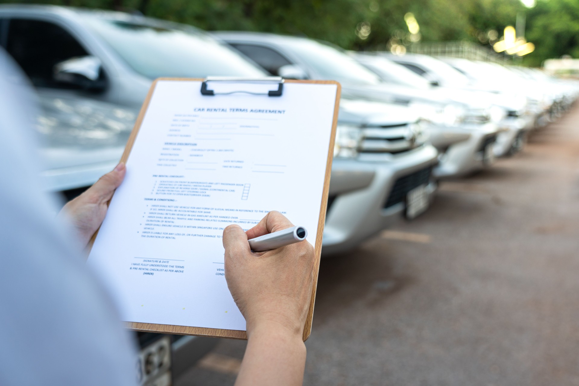 Signing on the agreement term of car rental service - Business and transportation service concept.